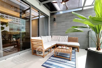 Stylish balcony with modern seating and lush greenery, perfect for relaxation.