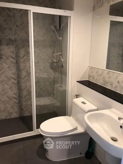 Modern bathroom with glass shower enclosure and sleek fixtures.