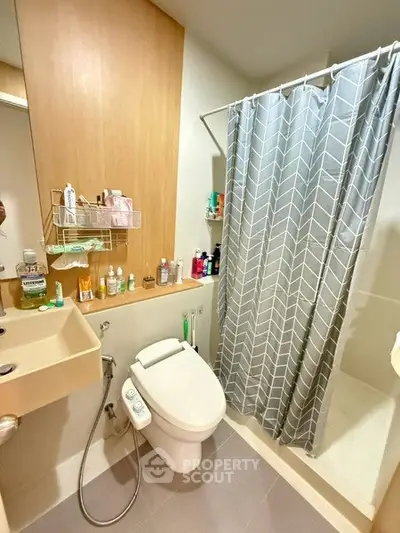 Modern bathroom with shower curtain and bidet in compact space