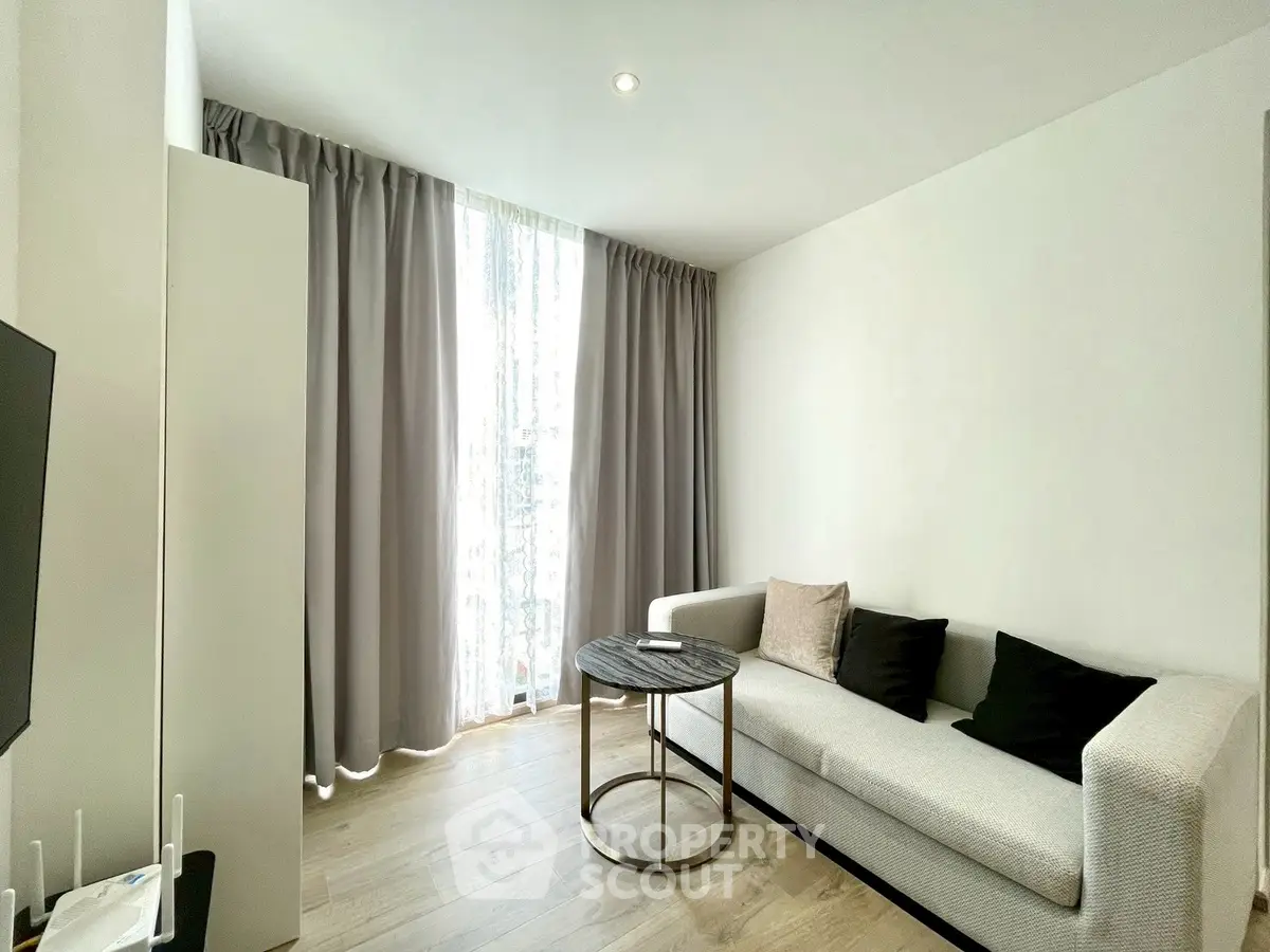 Modern living room with elegant sofa and natural light through large window.