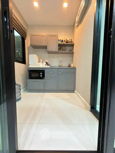 Modern compact kitchen with sleek cabinetry and built-in appliances in a stylish apartment.
