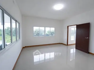 Spacious empty room with large windows and glossy floor, ideal for customization.