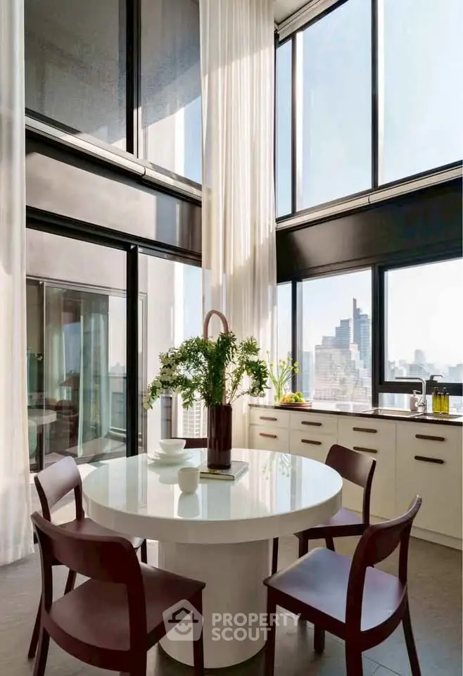 Stunning modern kitchen with high ceilings and panoramic city views, featuring sleek cabinetry and elegant dining area.