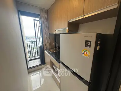 Modern kitchen with balcony view, featuring sleek appliances and stylish cabinetry.