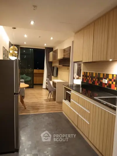 Modern kitchen with sleek cabinets and open layout leading to dining area