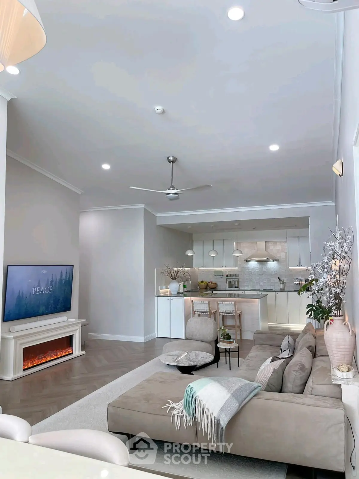 Modern open-plan living room with cozy fireplace and stylish kitchen