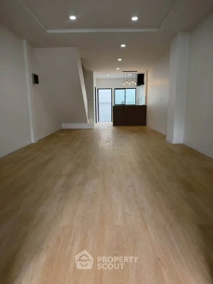 Spacious open-plan living area with modern kitchen and wooden flooring