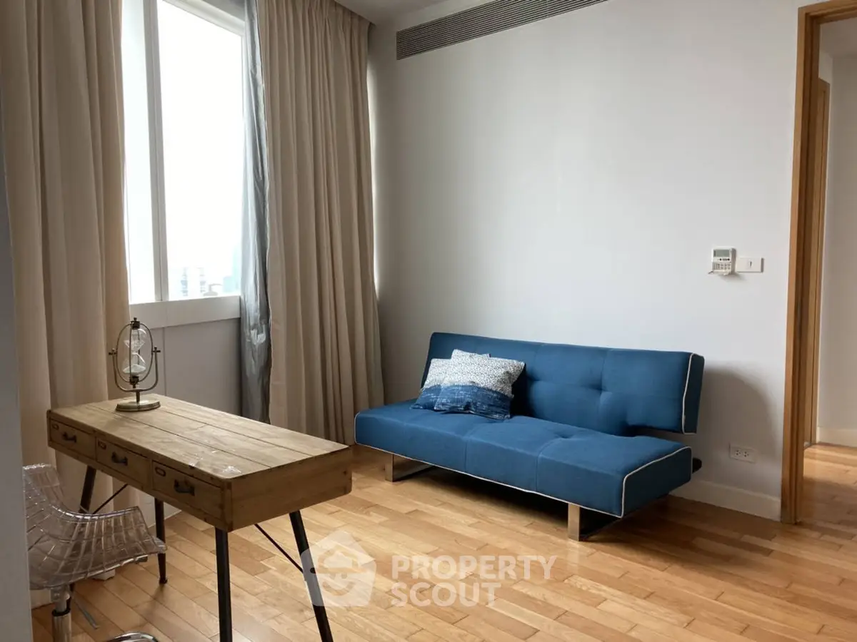 Chic modern living room with blue sofa and wooden desk, perfect for urban living.