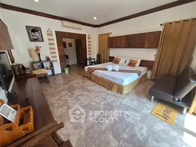 Spacious bedroom with elegant decor and cozy ambiance, featuring a large bed and stylish furnishings.