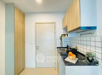 Modern kitchen with sleek cabinetry and stylish backsplash in a contemporary apartment.