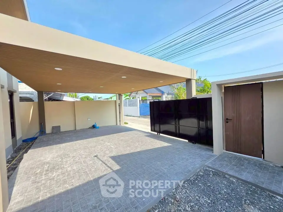 Spacious modern carport with sleek design and secure gate in a residential property.