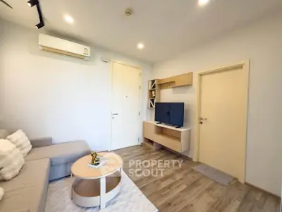 Modern living room with cozy sofa, TV, and stylish decor in a bright apartment.