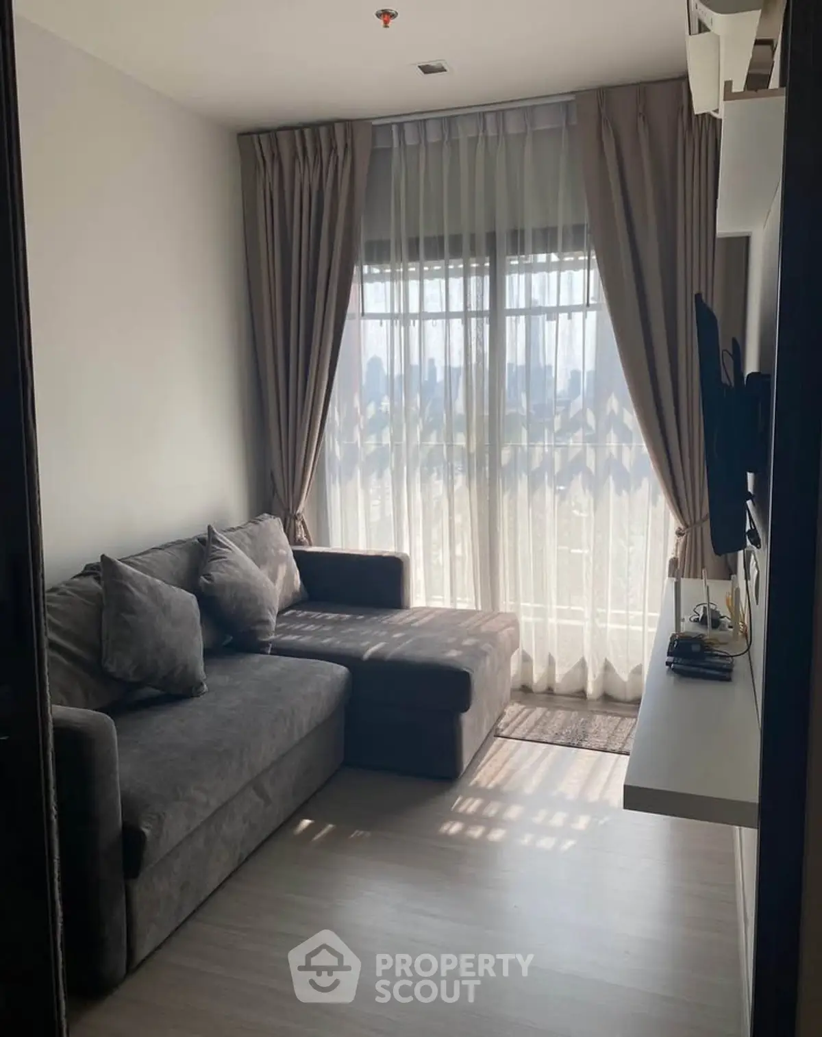 Cozy living room with modern sofa and large window offering city view