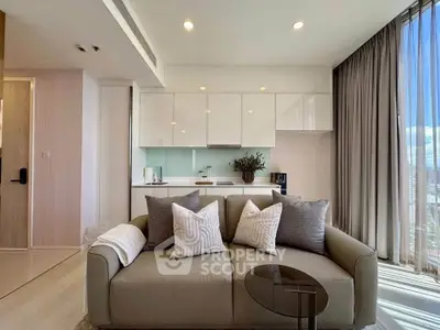 Modern living room with sleek kitchen, large windows, and stylish decor in a high-rise apartment.