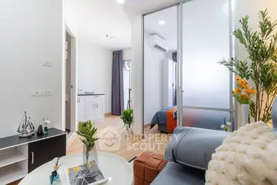 Modern apartment interior with stylish living room and cozy bedroom separated by glass partition.
