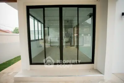 Modern sliding glass doors leading to a spacious balcony with a view