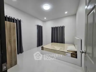 Spacious minimalist bedroom with modern decor and ample natural light.