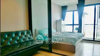 Modern bedroom with large windows and balcony access, featuring a cozy bed and stylish sofa.