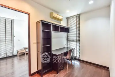 Modern study room with sleek desk and chair, featuring large windows and wooden flooring.