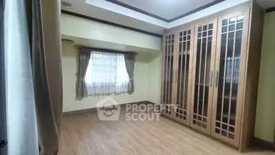 Spacious bedroom with elegant wooden wardrobe and natural light