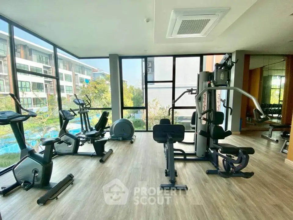 Modern gym with state-of-the-art equipment and large windows overlooking a scenic view.