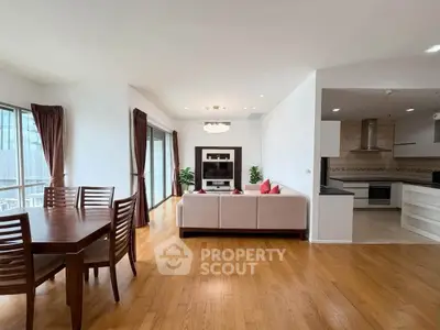 Spacious open-plan living room with dining area and modern kitchen in a bright apartment.