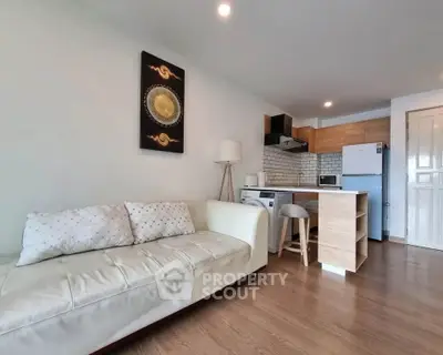 Modern open-layout living room with cozy sofa and stylish kitchen area