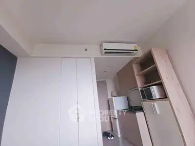 Modern compact kitchen with air conditioning and appliances in a cozy apartment.