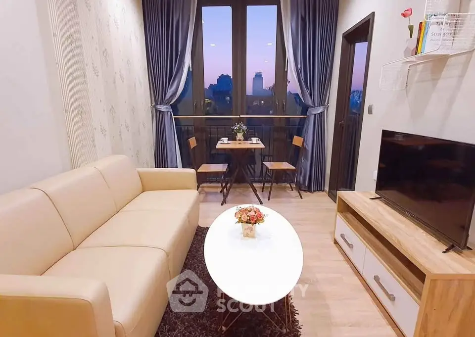 Charming living room with cozy seating and city view balcony, perfect for relaxation and entertaining.