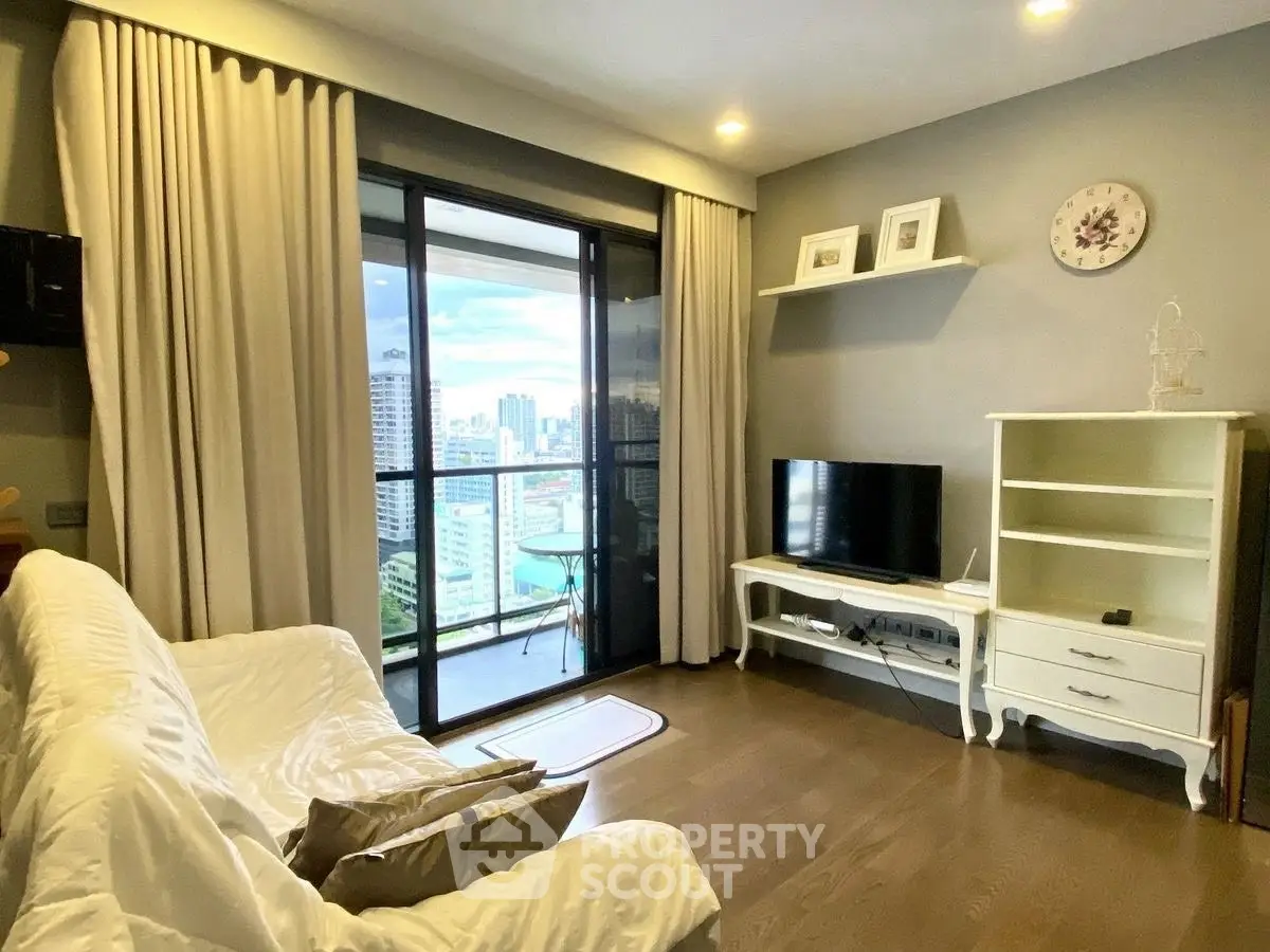 Stylish living room with balcony and city view, featuring cozy seating and modern decor.