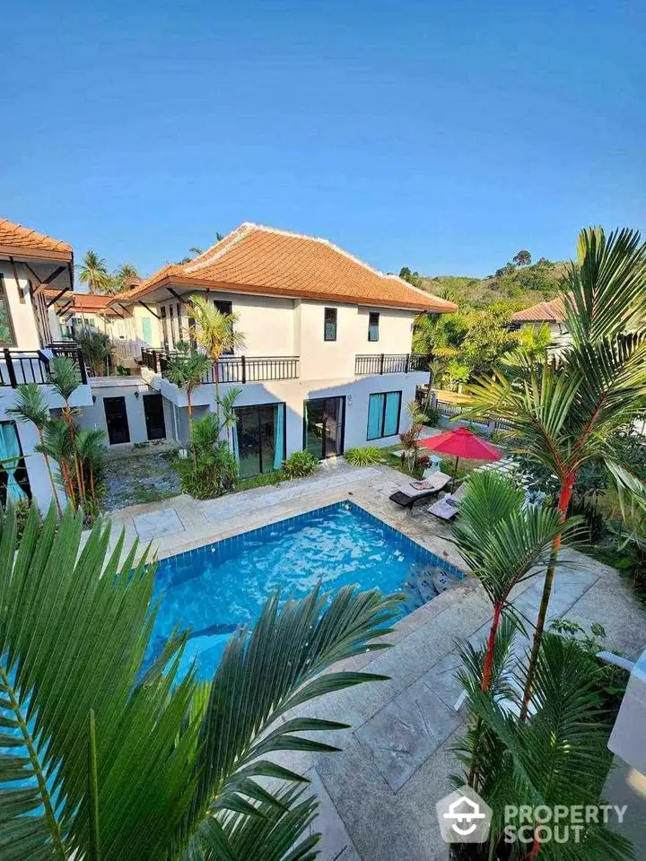 Luxurious villa with private pool and lush garden in tropical paradise setting.