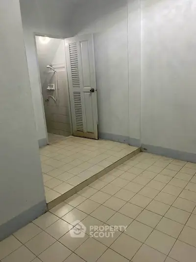 Minimalist bathroom with tiled floor and shower area