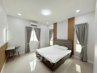 Spacious modern bedroom with elegant decor and ample natural light.