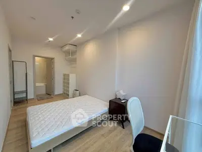 Modern minimalist bedroom with natural light and wooden flooring