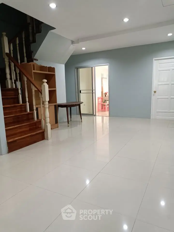 Spacious interior with elegant staircase and modern tiled flooring, perfect for stylish living.