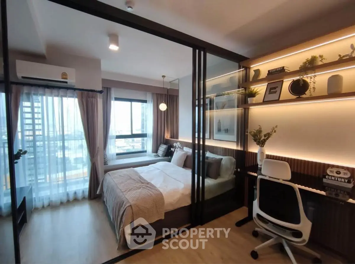Modern bedroom with study area and city view, featuring elegant decor and natural light.
