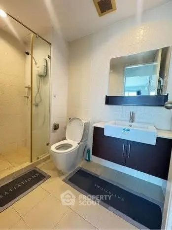 Modern bathroom with glass shower and sleek vanity in a contemporary apartment.