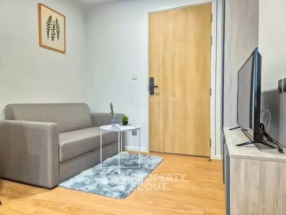 Cozy living room with modern sofa and TV setup, perfect for relaxation.