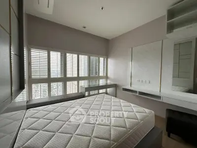 Modern bedroom with large windows and stylish decor in a high-rise apartment.