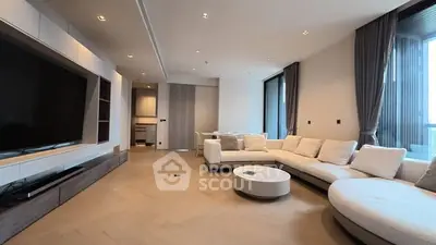 Luxurious modern living room with spacious seating and large TV, perfect for relaxation.