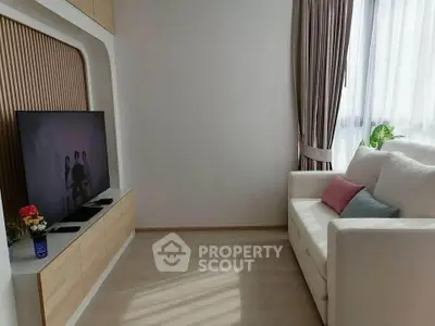 Modern living room with sleek TV setup and cozy white sofa, perfect for relaxation.