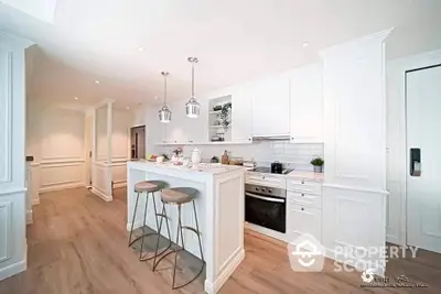 Spacious modern kitchen with white cabinetry, stainless steel appliances, and a chic breakfast bar, perfect for urban living.