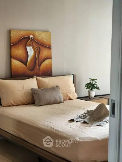 Cozy bedroom with modern art and neutral tones, perfect for relaxation.