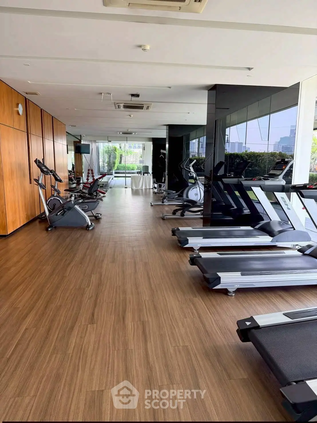 Modern gym with state-of-the-art equipment and large windows offering a scenic view.