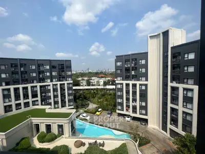 Modern apartment complex with pool and city skyline view
