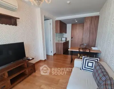 Charming living room with modern decor and open kitchen layout, perfect for cozy living.