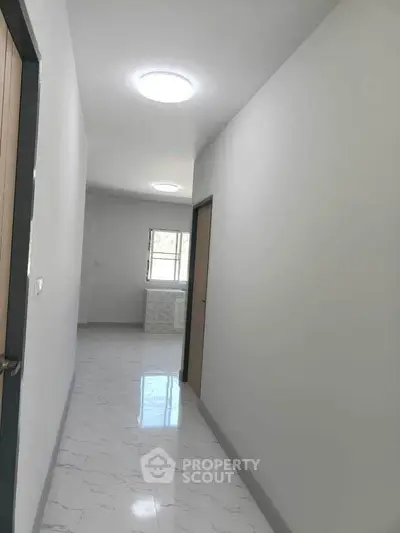 Bright hallway with modern lighting and marble flooring in a contemporary home.