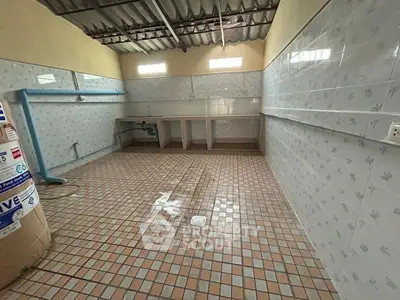 Spacious tiled kitchen area with open layout and ample natural light.