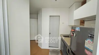 Compact kitchen with modern appliances and sleek design in cozy apartment.