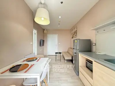 Modern apartment interior with dining area, cozy seating, and sleek kitchen appliances.
